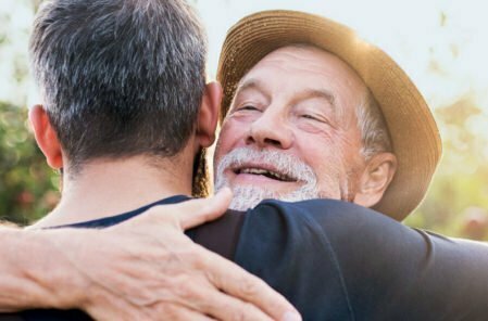 older man and son hugging
