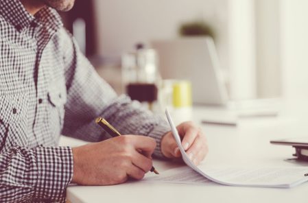 man signing a document