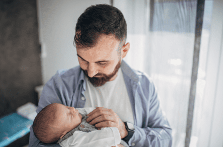 Father holding baby representing Bereaved Partner’s Paternity Leave UK